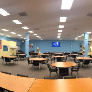 A spacious classroom with round tables and chairs arranged for group activities.