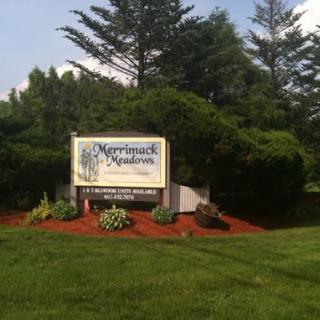Entrance sign surrounded by greenery and landscaping.