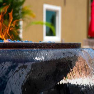 A close-up view of a decorative outdoor fountain with fire and water elements.