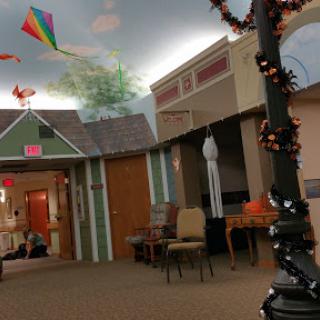 A vibrant indoor community space adorned with kites and Halloween decorations, creating a lively atmosphere.
