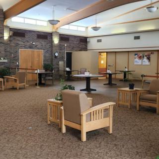 A modern waiting room with comfortable seating and tables.