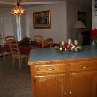A cozy kitchen and dining area featuring wooden cabinets, a table with chairs, and a decorative chandelier.