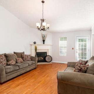 A cozy living room with a chandelier, comfortable sofas, and a fireplace.