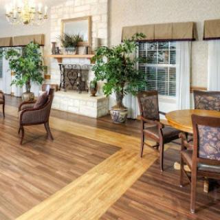 A cozy living room featuring elegant furniture, a warm fireplace, and potted plants.