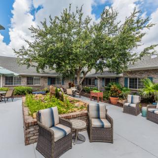 A well-furnished outdoor patio with comfortable seating and lush greenery.