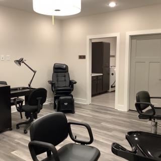 A modern salon interior featuring several chairs and workstations.
