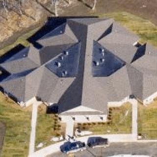 Aerial view of a large building with an intricate roof design.