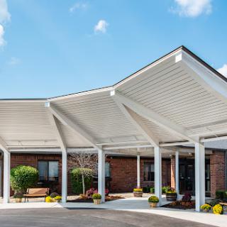 A modern entrance with a unique canopy design and well-maintained landscaping.