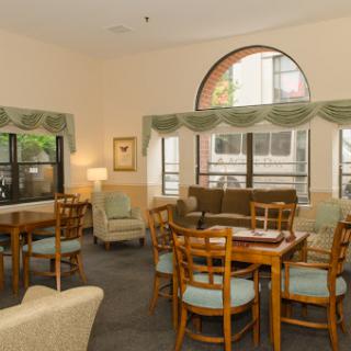 A cozy living space featuring wooden furniture and ample natural light.