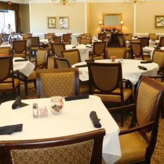 A spacious dining area with neatly arranged tables and chairs, ready for guests.