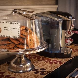 Freshly baked cookies displayed next to a coffee maker on a kitchen counter.