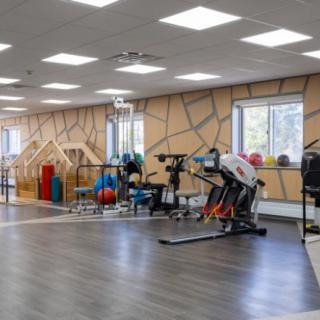 A spacious gym with various exercise equipment, including treadmills and workout stations.