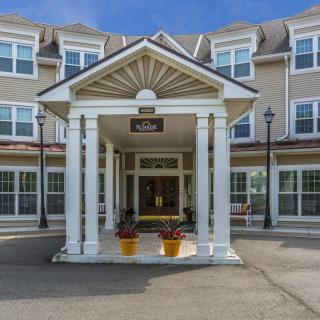 The entrance of a residential building with an awning and symmetrical architecture.