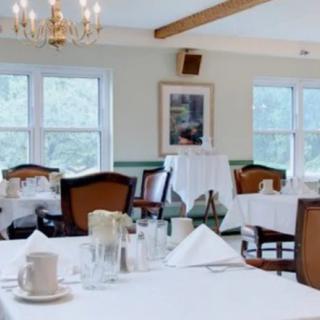 A cozy dining room with elegantly set tables and chairs.