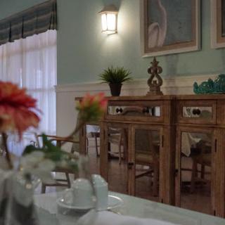 A beautifully designed dining room featuring elegant wooden furniture, decorative plants, and artworks.