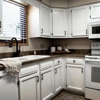 A modern kitchen with white cabinets and appliances.