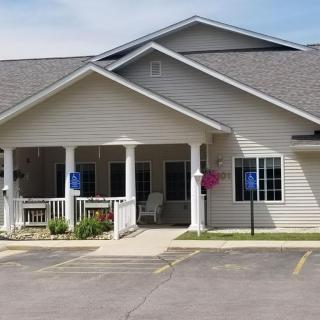 A single-story house with a front porch and a parking area in front.