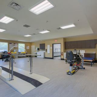 A spacious rehabilitation therapy room equipped with exercise equipment, designed for patient recovery and physical therapy.