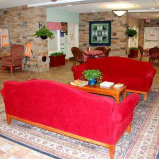 A cozy lobby area featuring vibrant red sofas and a decorative rug.