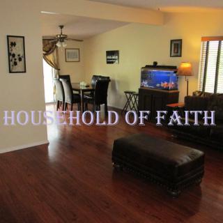 A cozy living room with hardwood floors, featuring a dining area, leather seating, and an aquarium.