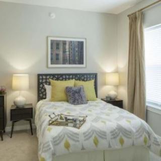 A cozy bedroom with modern decor and warm lighting.