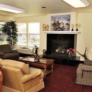 A cozy living room with sofas, a coffee table, and a fireplace surrounded by decorations.