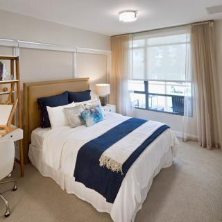 A modern bedroom with elegant decor and ample natural light.