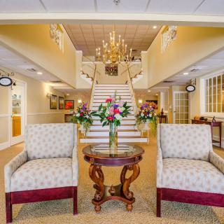 A luxurious lobby with a grand staircase and elegant seating area.