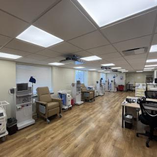 A spacious and well-lit patient care area in a medical facility, featuring treatment chairs and various medical equipment.