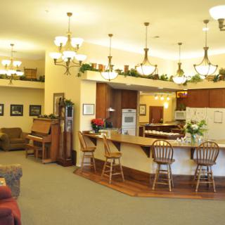 A cozy and inviting lobby area featuring a kitchen bar, comfortable seating, and warm lighting.