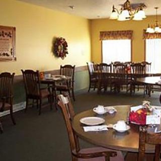 A cozy dining area with wooden tables and chairs, adorned with warm lighting and decor.