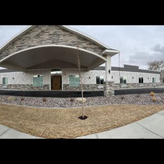 A modern house with stonework and open front yard.