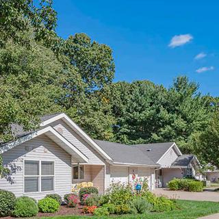 A suburban house surrounded by trees on a sunny day.