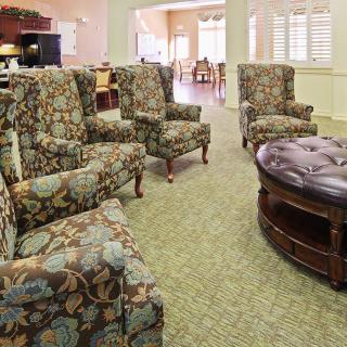 A cozy living room with floral upholstered armchairs and a large ottoman.