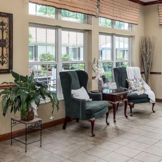 A cozy living room with comfortable chairs and large windows letting in natural light.