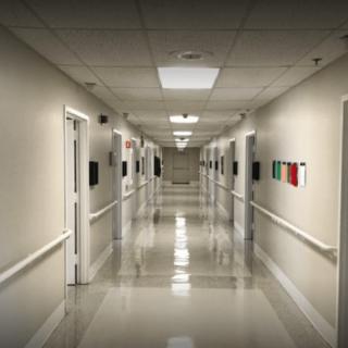 An empty hospital corridor with doors on both sides.