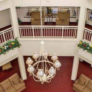 A spacious lobby with a central chandelier, comfortable seating, and decorative plants.