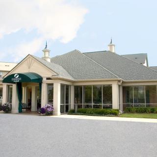 A building with a green awning at the entrance and a clear sky backdrop.