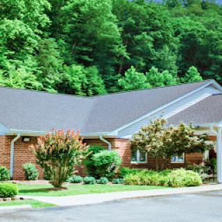 A charming residential building surrounded by lush greenery.