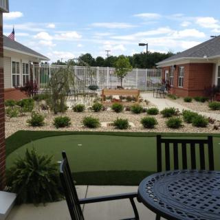 A residential patio area with outdoor furniture and a landscaped garden.