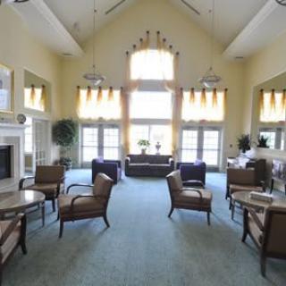 A spacious and bright living room with elegant seating and large windows.