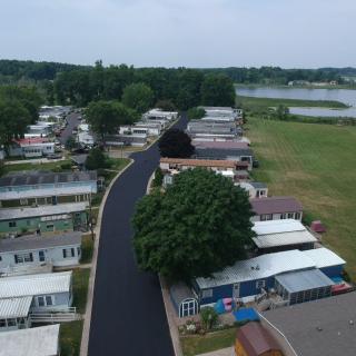 Aerial view of a residential area with mobile homes and a nearby lake.