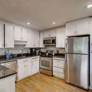 A modern kitchen with white cabinets and stainless steel appliances.