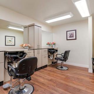 A modern beauty salon with sleek interior design, featuring stylish chairs and large mirrors.