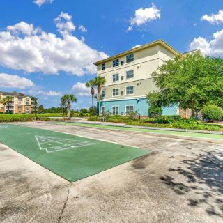 A residential building with a nearby basketball court under a partly cloudy sky.