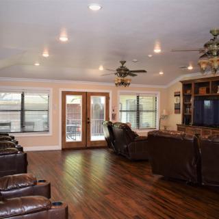Spacious living room with wood flooring, comfortable seating, and modern decor.