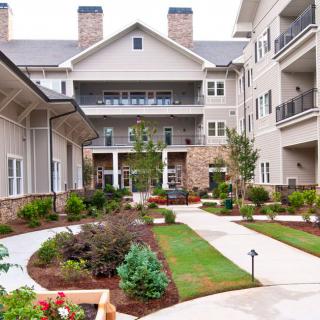 A landscaped courtyard between residential buildings with pathways and greenery.