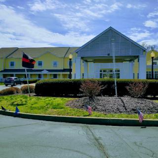 An inviting hotel entrance with well-maintained landscaping and flags fluttering in the breeze.