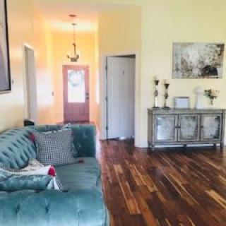 A cozy living room with a teal sofa and elegant hardwood flooring.