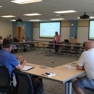 A group of people attending a presentation in a conference room.